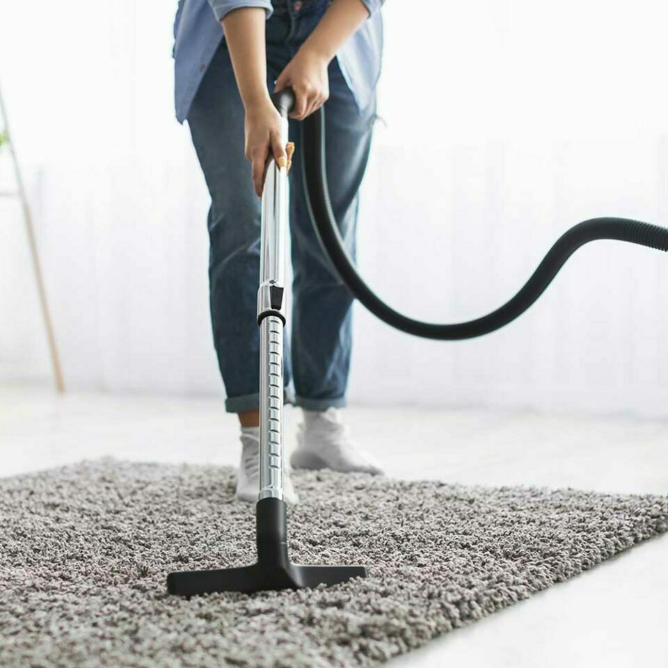 Vacuuming area rug | Yates Flooring
